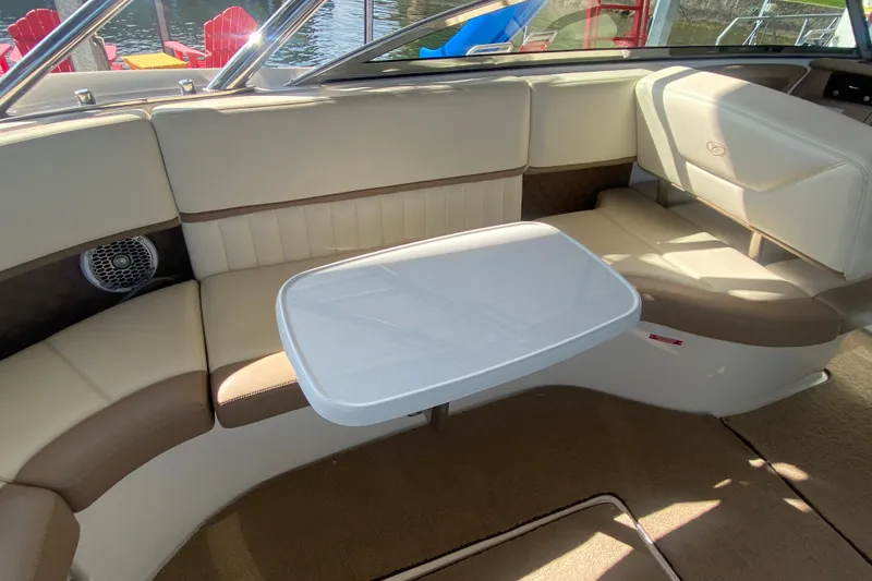 Slide: The Image of Interior of 2010 Cobalt 302 boat with beige seating and a white table. - 23