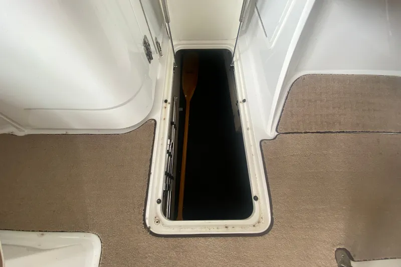 Slide: The Image of Open storage compartment on 2010 Cobalt 302 boat with visible paddle inside. - 20