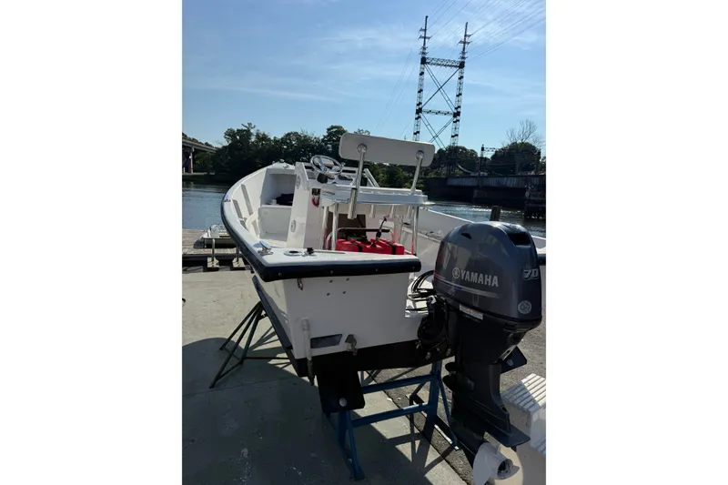 Slide: The Image of 2016 Allied 15 Sportsman boat with Yamaha motor docked by the river. - 5