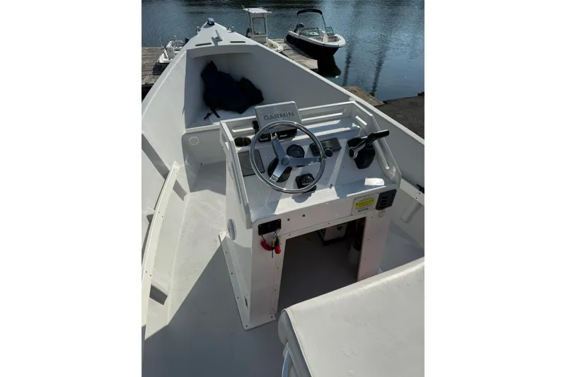 Slide: The Image of 2016 Allied 15 Sportsman boat interior with steering wheel and controls by the water. - 8