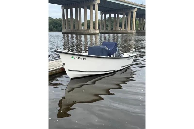 Slide: The Image of 2016 Allied 15 Sportsman boat docked on calm river under bridge. - 1