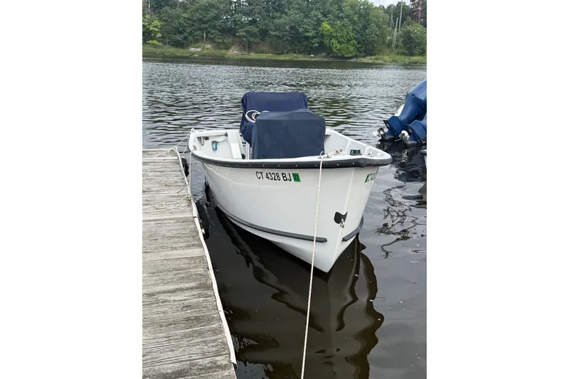 Slide: The Image of 2016 Allied 15 Sportsman boat docked on a calm lake with lush greenery. - 3