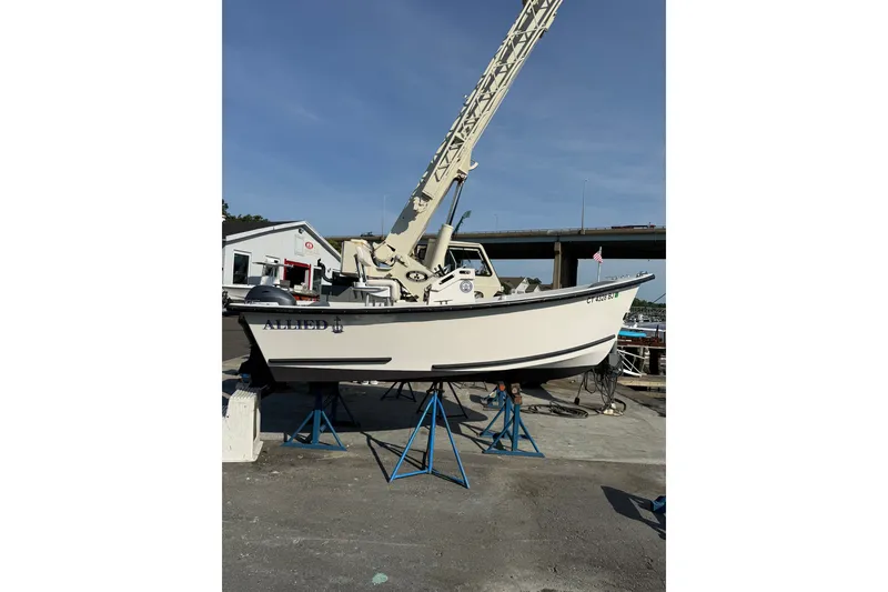 Slide: The Image of 2016 Allied 15 Sportsman boat on stands, dockside with crane in background. - 2