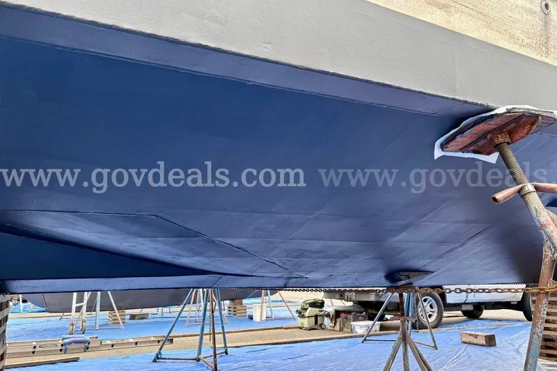 Slide: The Image of 2019 Armstrong Marine 38 Monohull boat hull in dry dock, blue paint, supported by stands. - 56