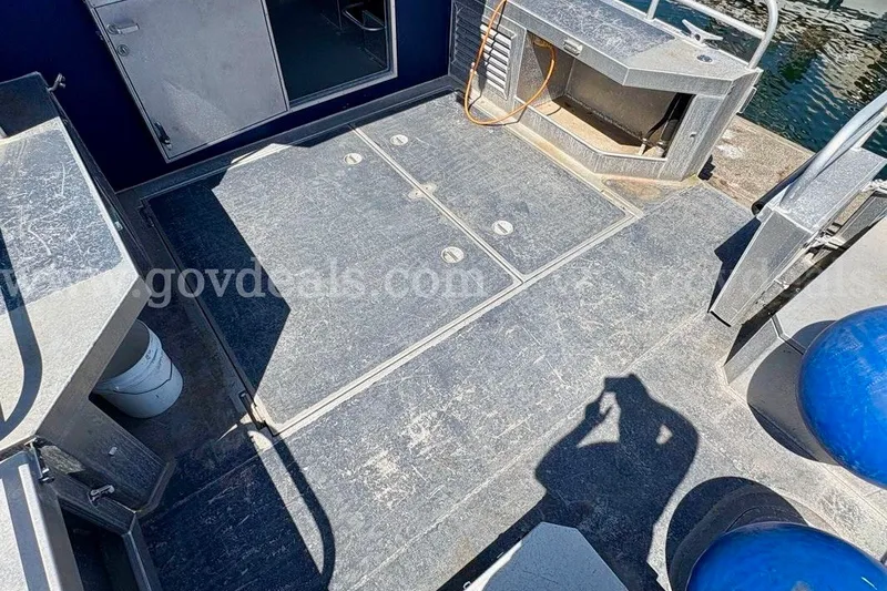 Slide: The Image of 2019 Armstrong Marine 38 Monohull deck with storage compartments and railing, docked by water. - 11