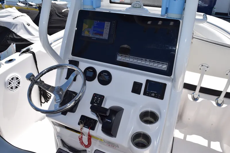 Slide: The Image of 2023 Tidewater 232 SS boat dashboard with steering wheel and electronic controls. - 13