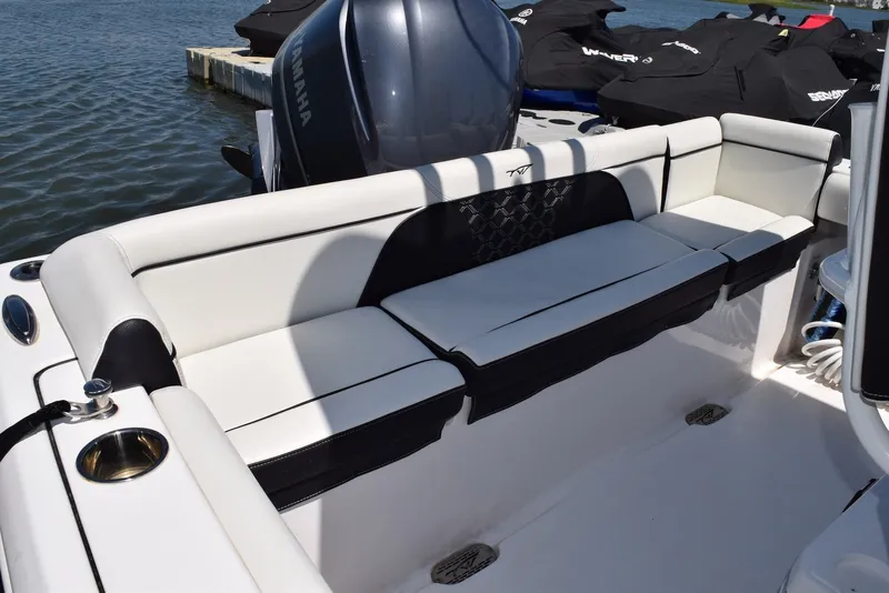 Slide: The Image of 2023 Tidewater 232 SS boat interior with white seating and Yamaha engine. - 15