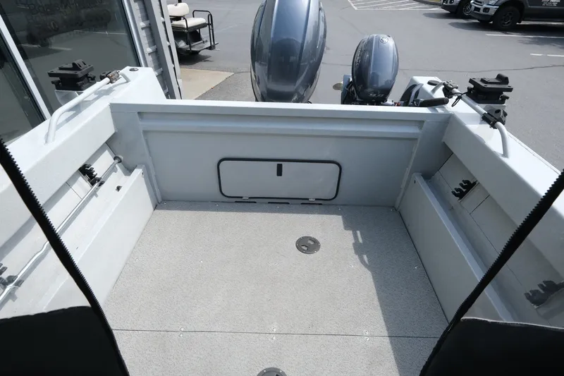 Slide: The Image of 2018 Duckworth 18 Advantage Outboard boat interior with dual engines, parked outdoors. - 7