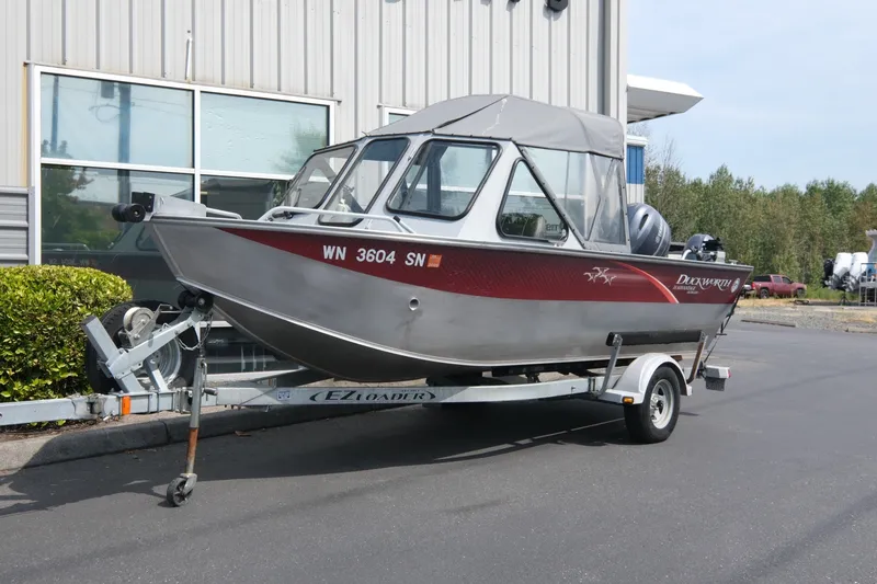The Image of 2018 Duckworth 18 Advantage Outboard boat on trailer, parked outside a building. - 1