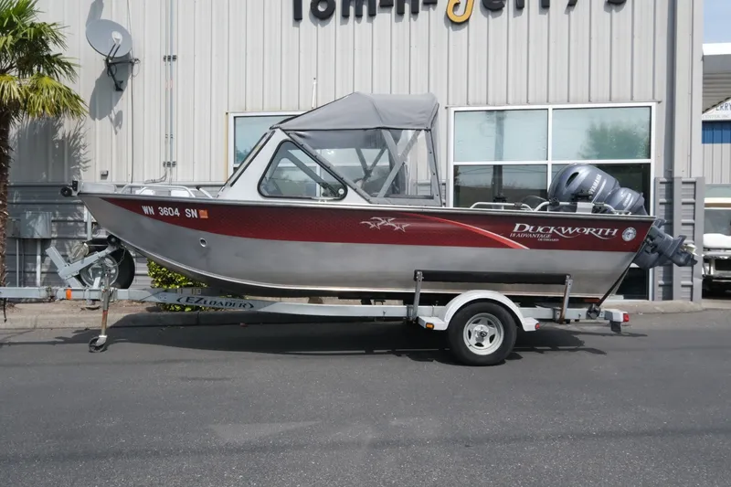 Slide: The Image of 2018 Duckworth 18 Advantage Outboard boat on trailer, parked outside a building. - 2