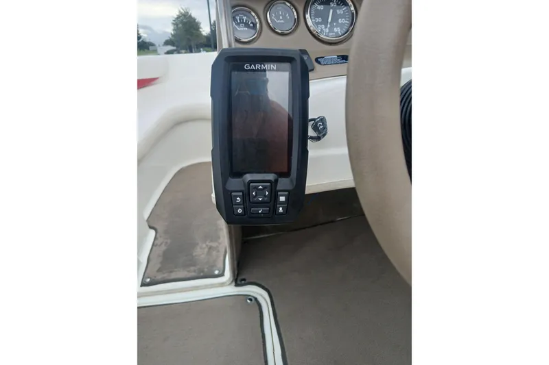 Slide: The Image of Garmin device on 2003 Larson SEi 180 boat dashboard with gauges in view. - 9