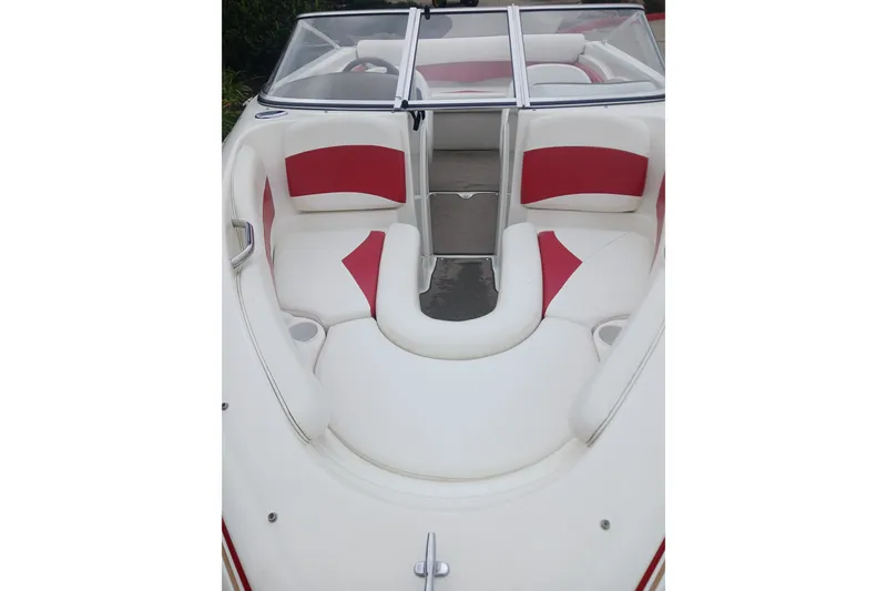 Slide: The Image of 2003 Larson SEi 180 boat interior with white and red seating, featuring cup holders. - 8