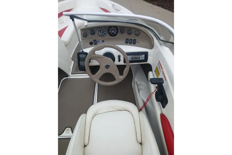 Slide: The Image of 2003 Larson SEi 180 boat cockpit with steering wheel and dashboard controls. - 10