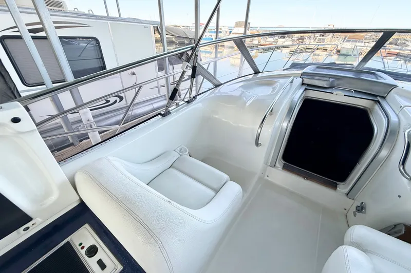 Slide: The Image of 2005 Cranchi Endurance 41 yacht interior with white seating and marina view. - 8