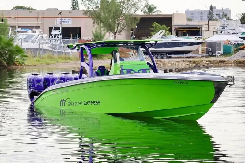 The Image of A bright green Midnight Express 39S Open boat from 2000 is docked on the water. - 0