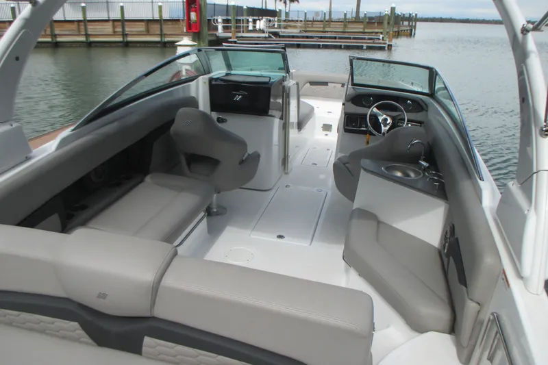 Slide: The Image of 2022 Four Winns HD8 OB boat interior with seating and steering wheel, dockside view. - 9