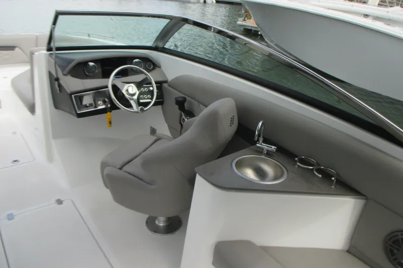 Slide: The Image of 2022 Four Winns HD8 OB boat interior with steering wheel, sink, and seating. - 13