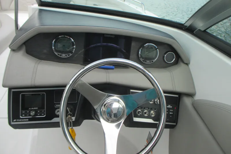 Slide: The Image of 2022 Four Winns HD8 OB boat dashboard with steering wheel and control panel. - 15
