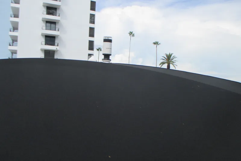 Slide: The Image of Modern building and palm trees behind a Four Winns HD8 OB boat, 2022 model. - 23