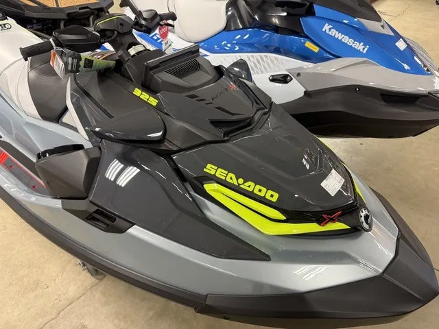 Slide: The Image of A gray 2026 Sea-Doo RXT-X jet ski is parked next to a blue Kawasaki jet ski. - 9