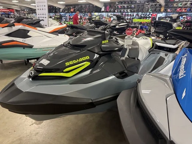 Slide: The Image of A 2026 Sea-Doo RXT-X jet ski is displayed in a showroom, surrounded by other watercraft. - 4