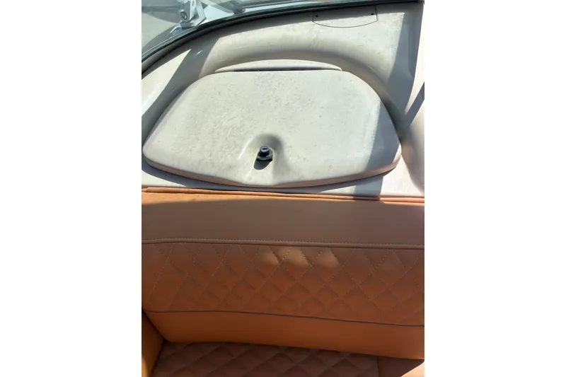 Slide: The Image of 2000 MasterCraft MariStar 210 VRS boat interior with tan leather seating and storage compartment. - 18
