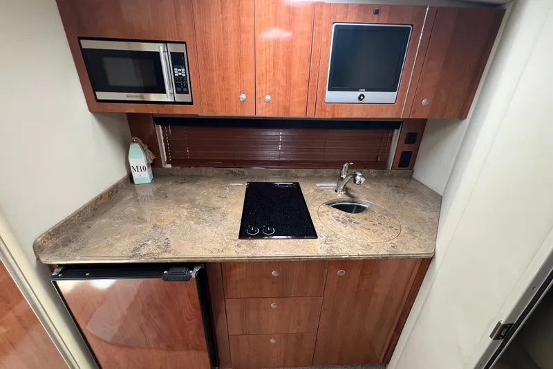 Slide: The Image of 2008 Cruisers Yachts 330 Express kitchen with microwave, sink, and stovetop. - 27