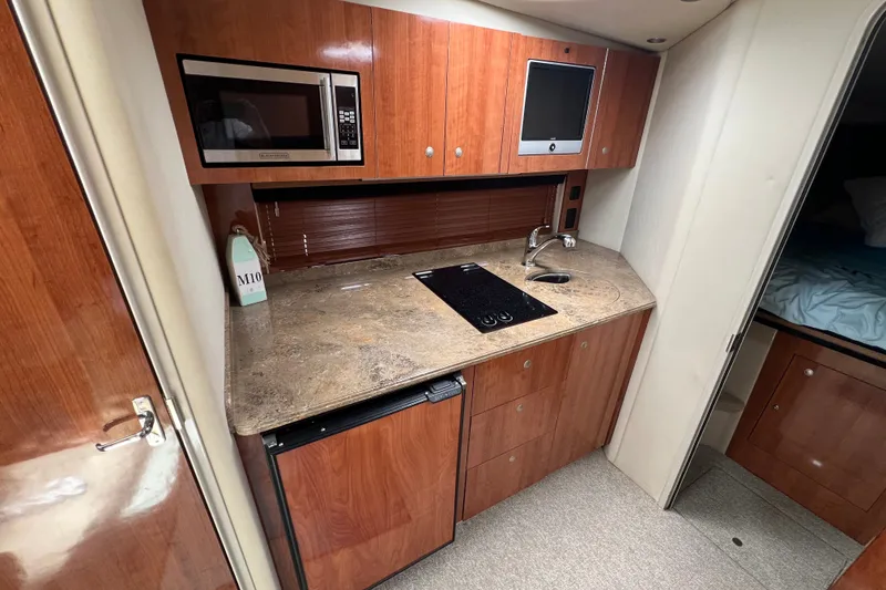 Slide: The Image of 2008 Cruisers Yachts 330 Express kitchen with microwave, sink, and compact fridge. - 26