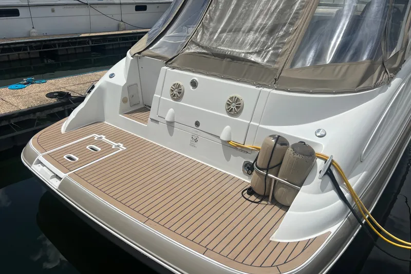 Slide: The Image of 2008 Cruisers Yachts 330 Express boat docked, featuring a spacious rear deck and protective canopy. - 12
