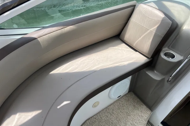 Slide: The Image of 2008 Cruisers Yachts 330 Express interior seating with beige upholstery and cup holder. - 21