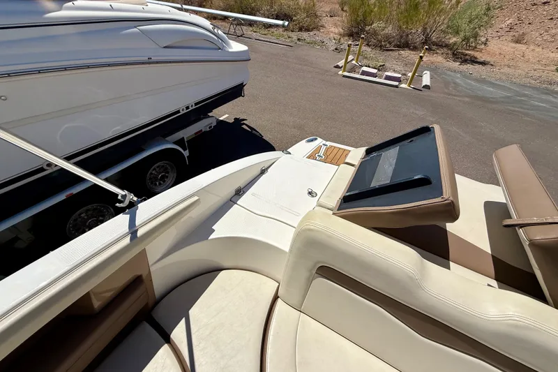 Slide: The Image of 2014 Chaparral 226 SSi boat interior with seating and dashboard, parked on a trailer. - 26