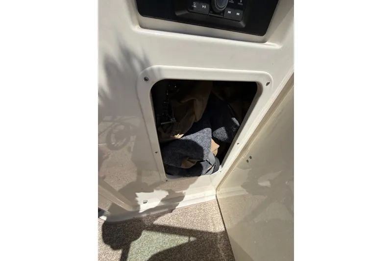 Slide: The Image of Storage compartment in 2014 Chaparral 226 SSi boat, partially open with items inside. - 32