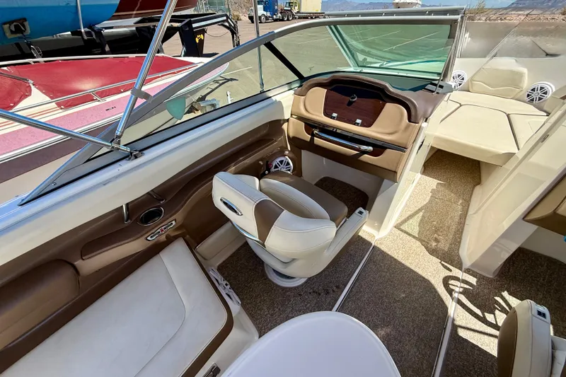 Slide: The Image of Interior of a 2014 Chaparral 226 SSi boat with beige seating and dashboard. - 28