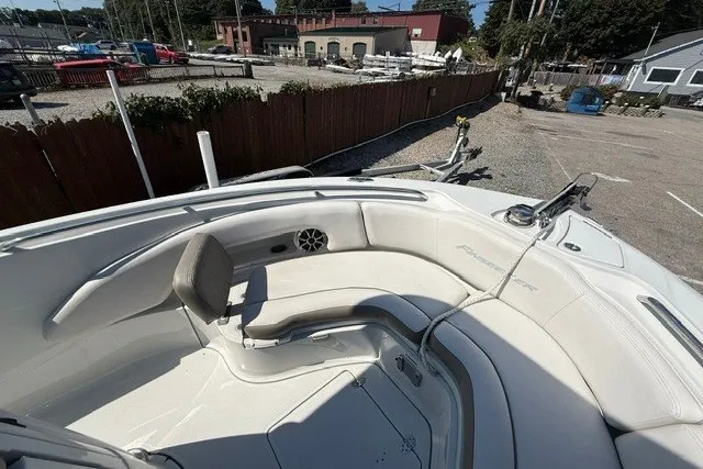 Slide: The Image of 2022 Finseeker 230 FS boat interior with white seating and speaker, docked outdoors. - 18