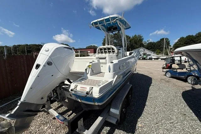 Slide: The Image of 2022 Finseeker 230 FS boat on trailer, featuring powerful outboard motor, parked outdoors. - 3