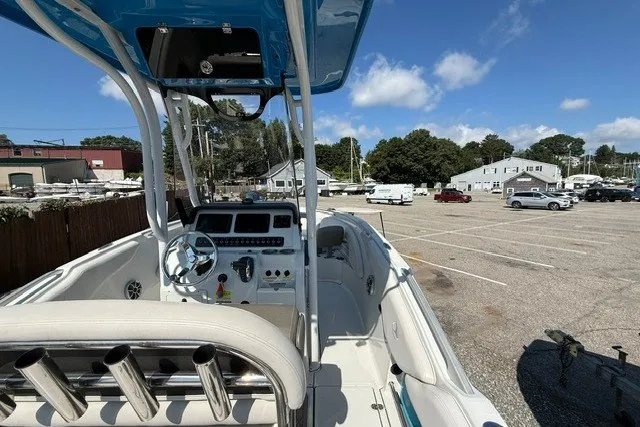 Slide: The Image of 2022 Finseeker 230 FS boat interior with steering wheel and controls in a parking lot. - 10