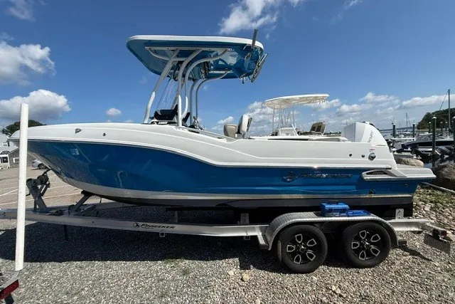 Slide: The Image of 2022 Finseeker 230 FS boat on trailer, blue and white design, parked outdoors. - 6