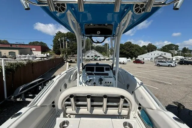 Slide: The Image of 2022 Finseeker 230 FS boat interior with steering console, parked in a marina lot. - 9