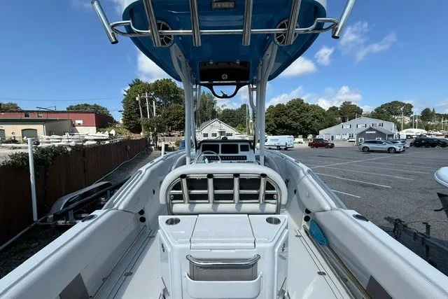 Slide: The Image of 2022 Finseeker 230 FS boat interior with center console and seating, parked in a marina. - 7