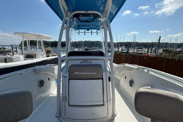 Slide: The Image of 2022 Finseeker 230 FS boat interior with seating and console, docked at marina. - 19