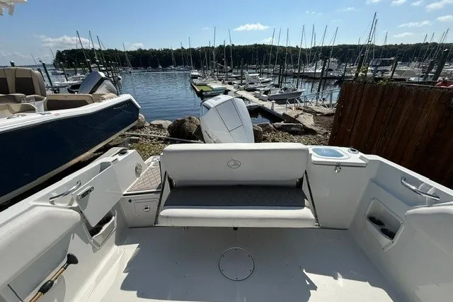 Slide: The Image of 2022 Finseeker 230 FS boat interior with seating, docked at a marina. - 12