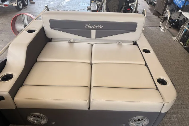 Slide: The Image of 2025 Barletta Cabrio 24UE boat seating with beige upholstery and integrated cup holders. - 19