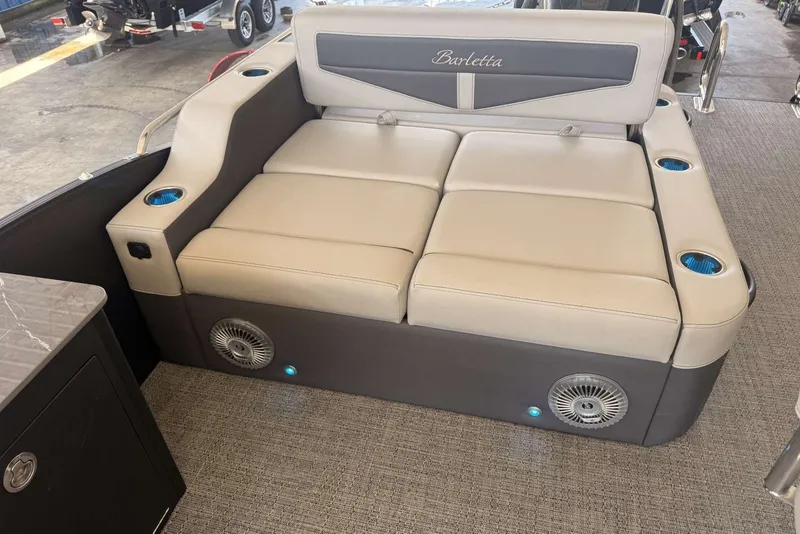 Slide: The Image of Luxurious seating on 2025 Barletta Cabrio 24UE boat with integrated cup holders and speakers. - 14