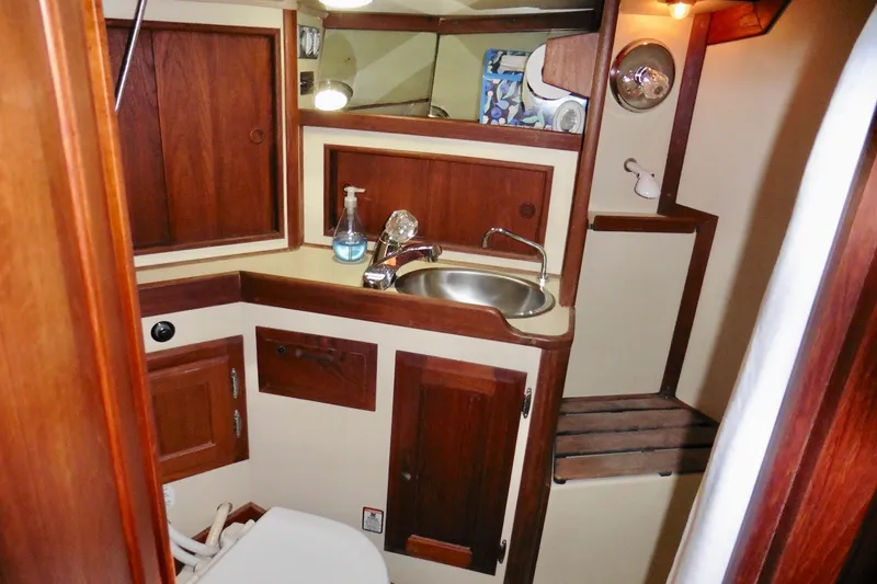 Slide: The Image of 1986 Ericson 35.3 yacht bathroom with wooden cabinetry and stainless steel sink. - 24