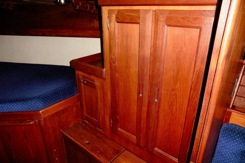 Slide: The Image of Interior of 1986 Ericson 35.3 sailboat with wooden cabinetry and blue upholstered seating. - 26