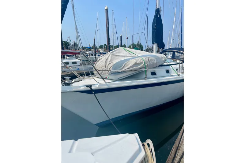 Slide: The Image of 1986 Ericson 35.3 sailboat docked at marina, covered sails, clear sky. - 7