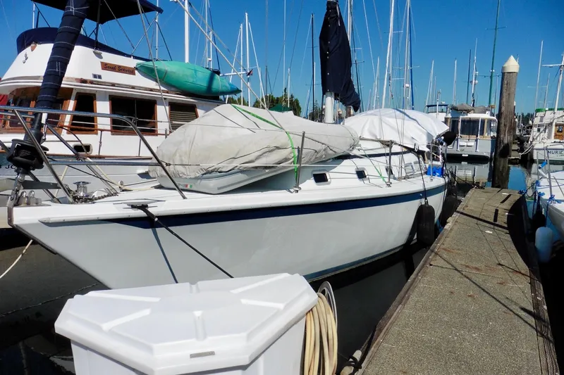 Slide: The Image of 1986 Ericson 35.3 sailboat docked at a marina, surrounded by other boats. - 8