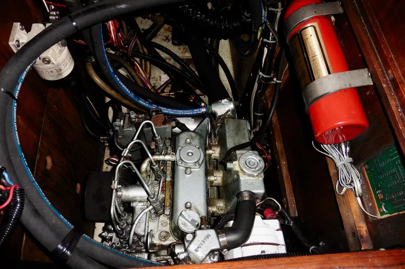 Slide: The Image of Engine compartment of a 1986 Ericson 35.3 sailboat, featuring mechanical components and wiring. - 27
