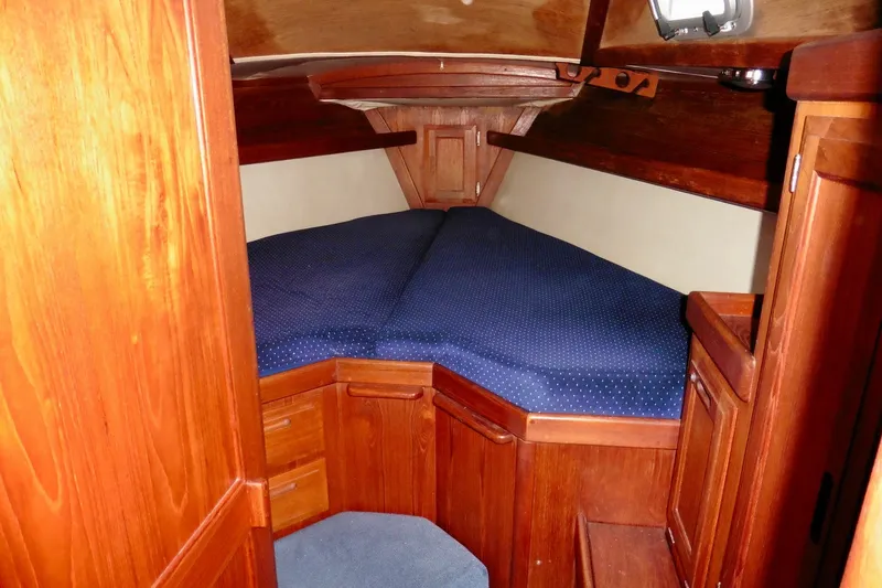 Slide: The Image of Cozy cabin interior of 1986 Ericson 35.3 sailboat with wooden finish and blue bedding. - 25