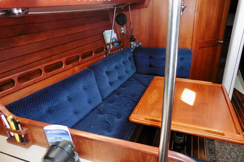 Slide: The Image of Interior of 1986 Ericson 35.3 sailboat with blue cushioned seating and wooden table. - 22